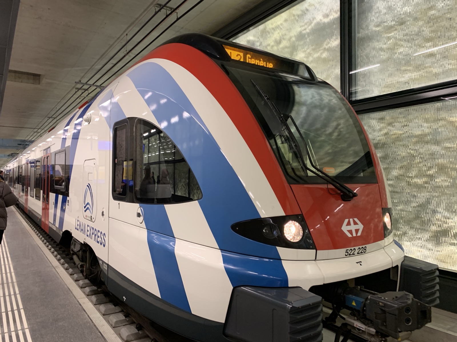 A Léman Express train at a station platform in Geneva